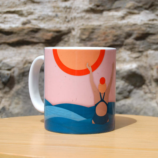 Orange, pink and blue sea swimming mug including sun, waves and female with hands up in joy